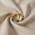 Annika – Guldring med blomsterdetaljer og Smaragd-element.