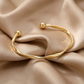 Elegant åbent armbånd i guld
